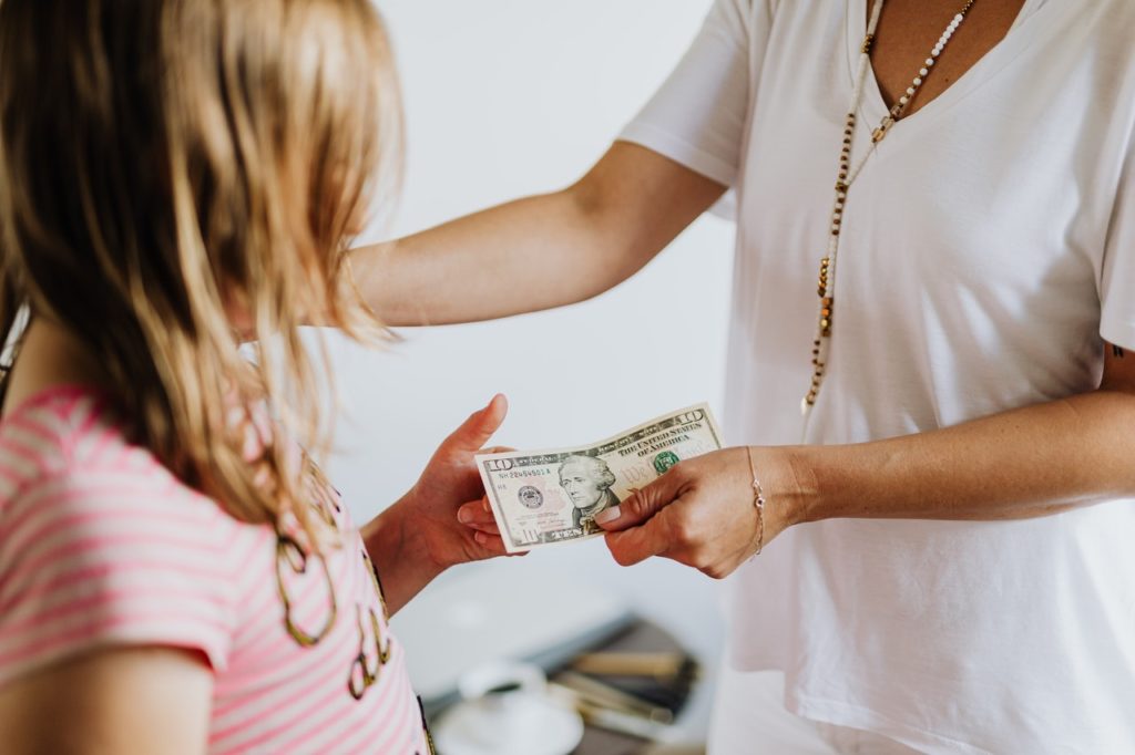 parent handing over money to child