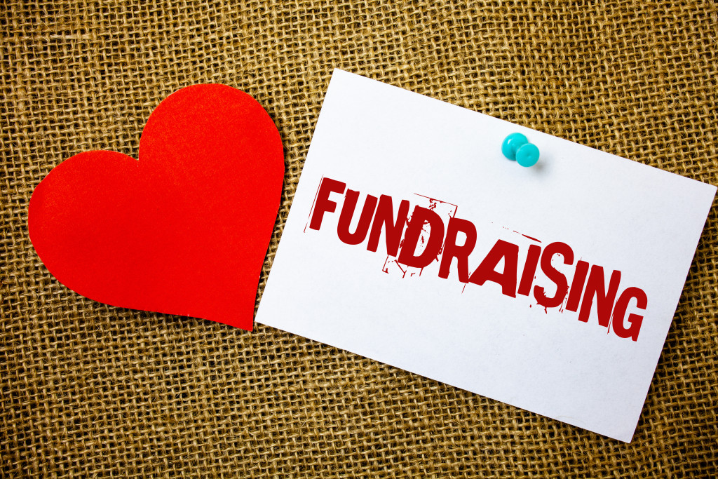 a heart and a paper with the word "fundraising" printed on it