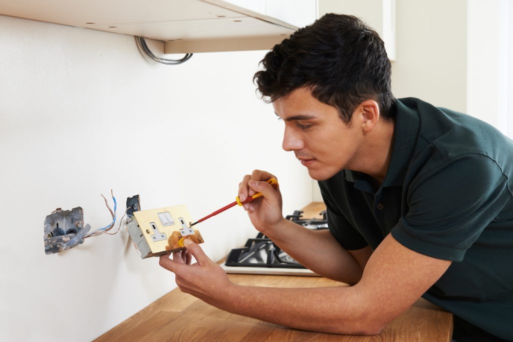 man fixing an outlet