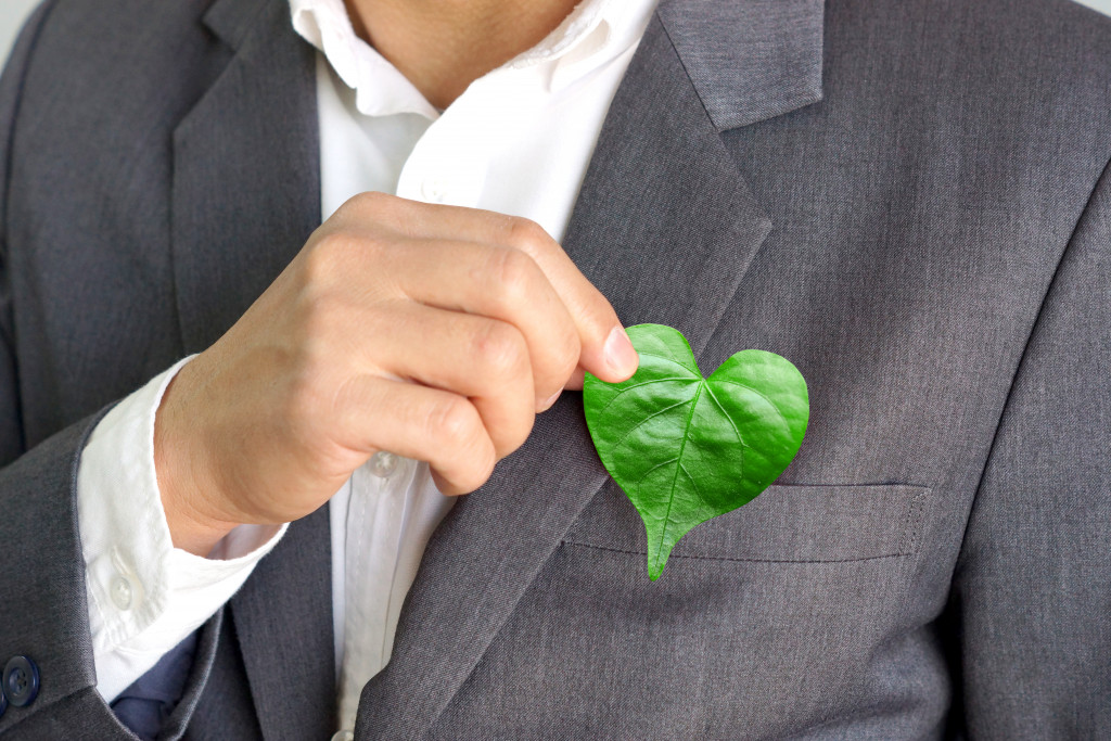 businessman with a heart shaped leaf being inserted in his coat's pocket