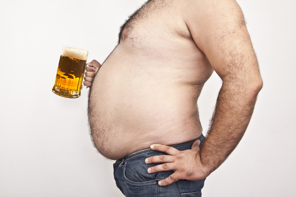 obese man holding beer